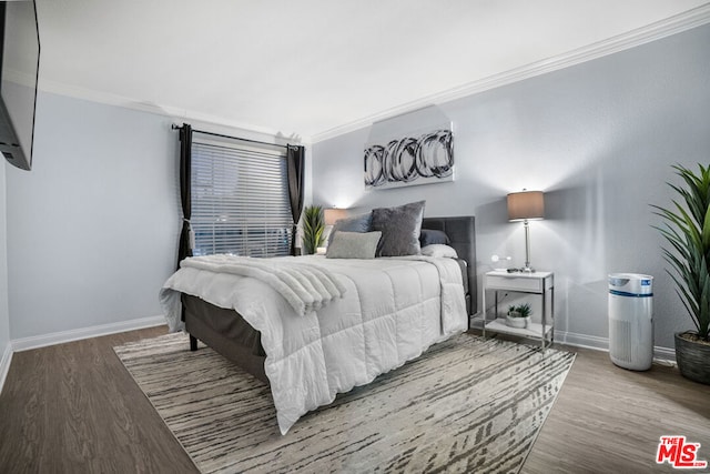 bedroom featuring crown molding and light hardwood / wood-style floors