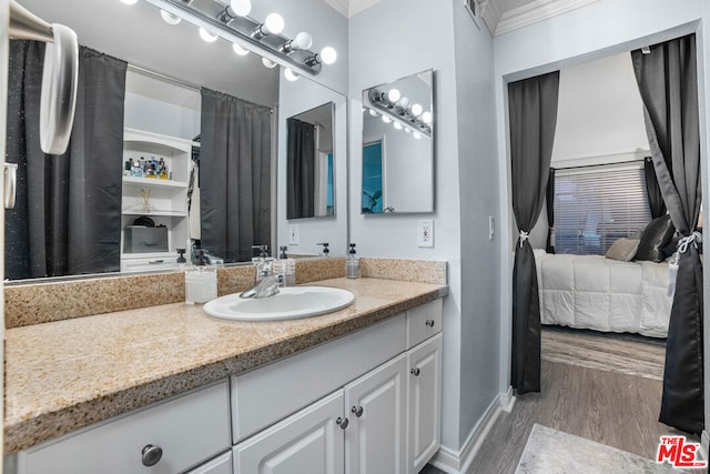 bathroom with hardwood / wood-style floors, vanity, and ornamental molding