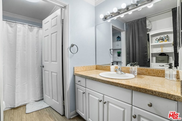 bathroom featuring hardwood / wood-style floors, vanity, and crown molding