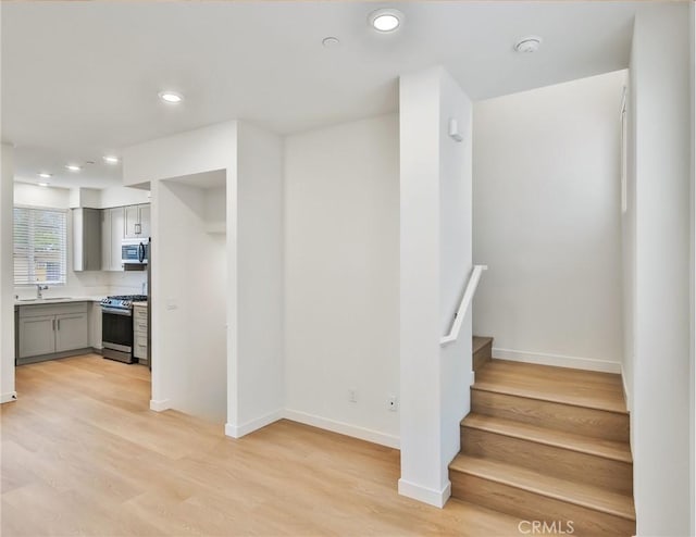 stairway featuring hardwood / wood-style floors and sink