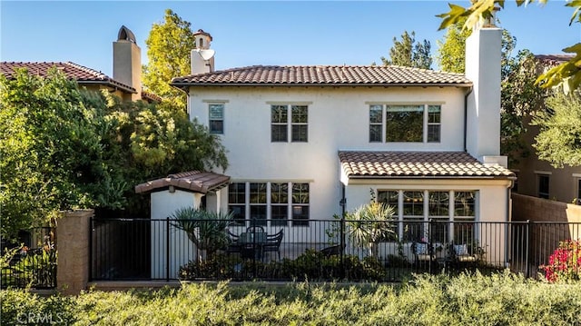102 Catalonia, Irvine, CA 92618 - back of house with stucco siding, a tile roof, a chimney, and fence