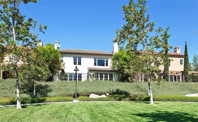 rear view of property with a lawn