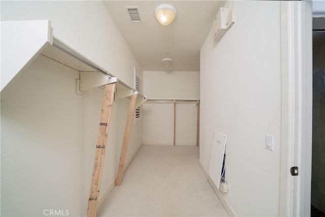 walk in closet featuring light colored carpet