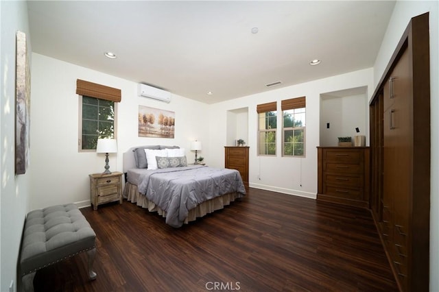 bedroom featuring a closet, dark wood-type flooring, and a wall mounted air conditioner