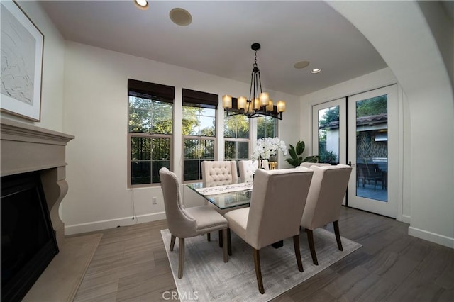 dining area with hardwood / wood-style flooring, plenty of natural light, french doors, and a notable chandelier