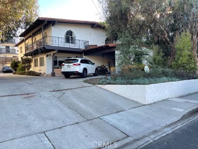 view of home's exterior featuring driveway, a balcony, and stucco siding