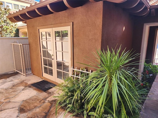 view of exterior entry with french doors and a patio area