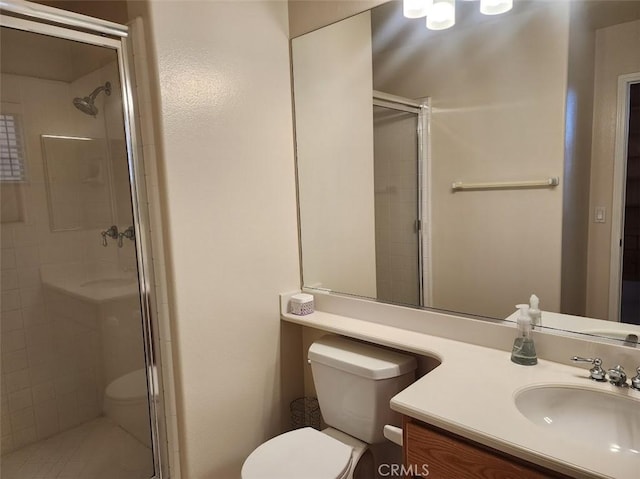 bathroom with toilet, vanity, and walk in shower