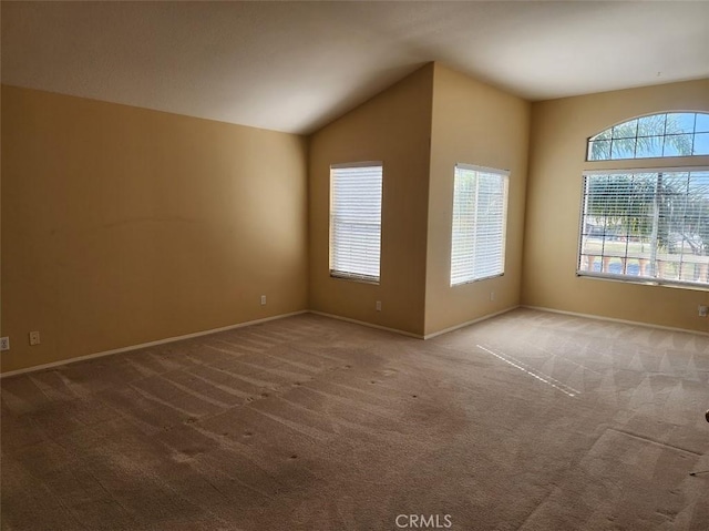 carpeted spare room with vaulted ceiling