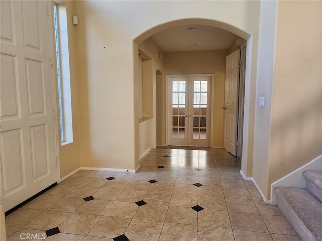 entrance foyer featuring french doors and light tile patterned floors