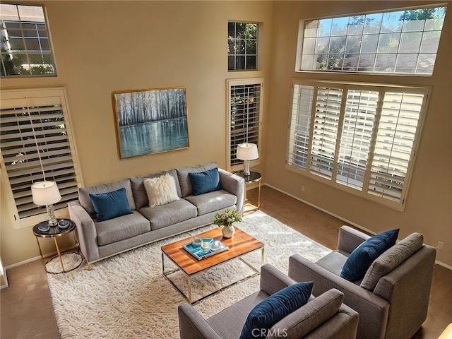 living room with a towering ceiling and carpet floors