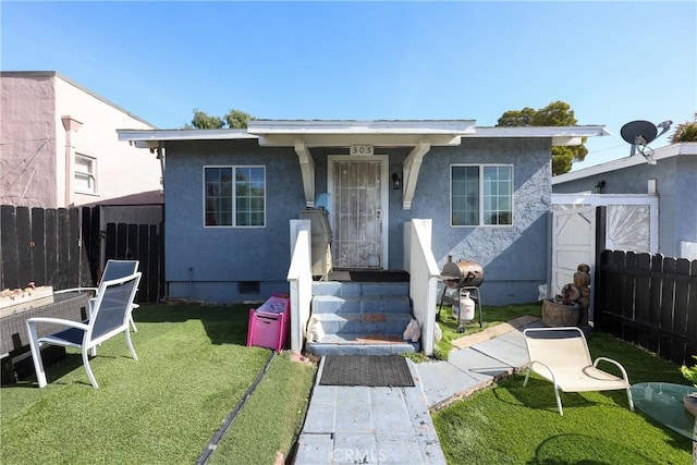 bungalow featuring a front lawn