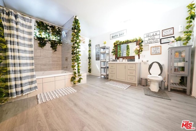 full bathroom featuring wood-type flooring, vanity, toilet, and shower / tub combo with curtain