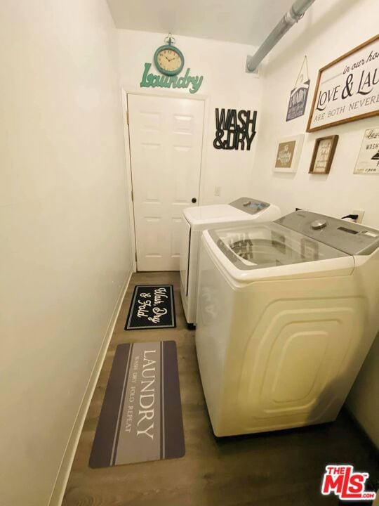 laundry room with separate washer and dryer and dark hardwood / wood-style floors