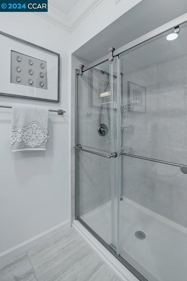 bathroom with an enclosed shower and ornamental molding