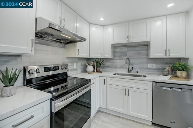 kitchen with backsplash, sink, white cabinetry, and stainless steel appliances