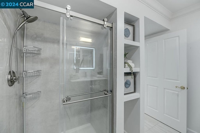 bathroom featuring a shower with shower door and crown molding