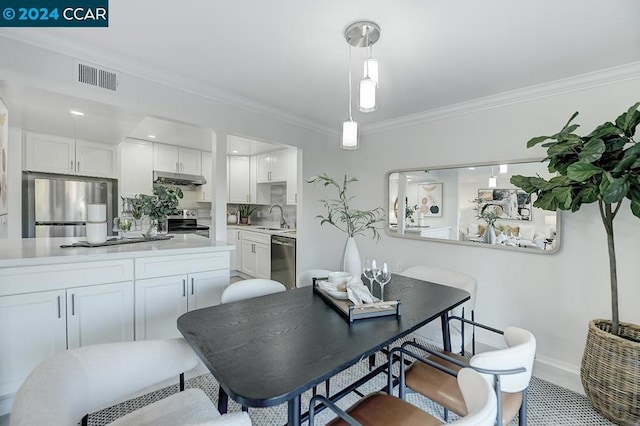 dining area featuring sink and ornamental molding