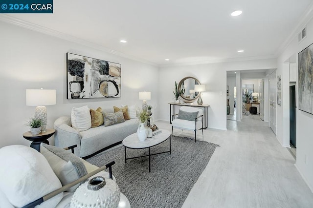 living room with light wood-type flooring and ornamental molding