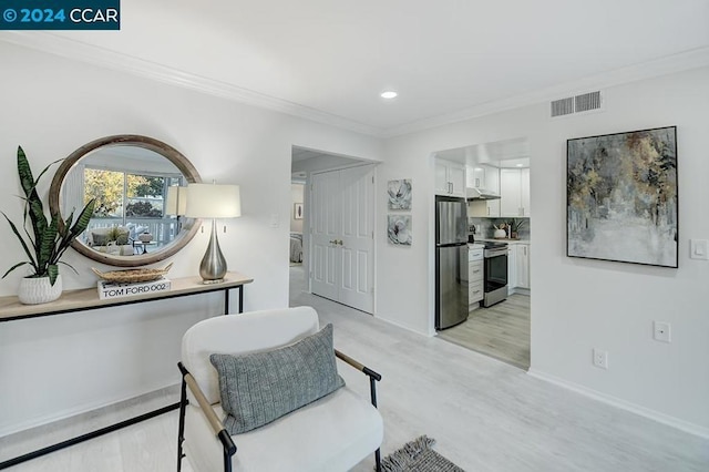 living area featuring light hardwood / wood-style floors and ornamental molding