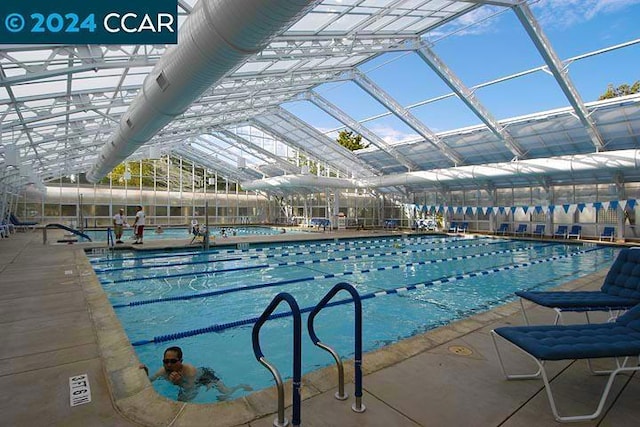 view of swimming pool with glass enclosure