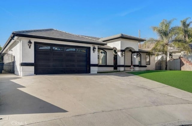 view of front facade featuring a garage, concrete driveway, a tile roof, a front lawn, and stucco siding