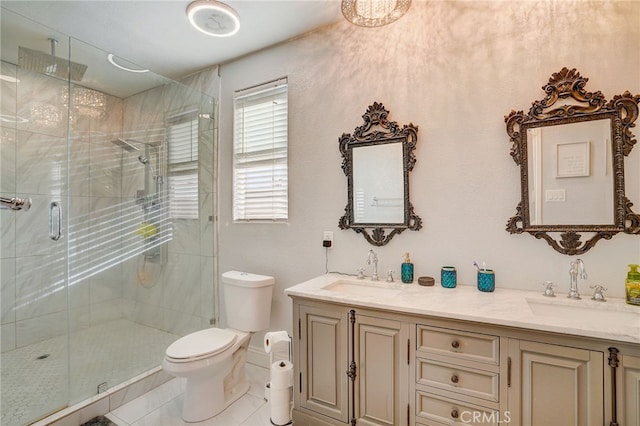 full bathroom featuring toilet, a stall shower, double vanity, and a sink