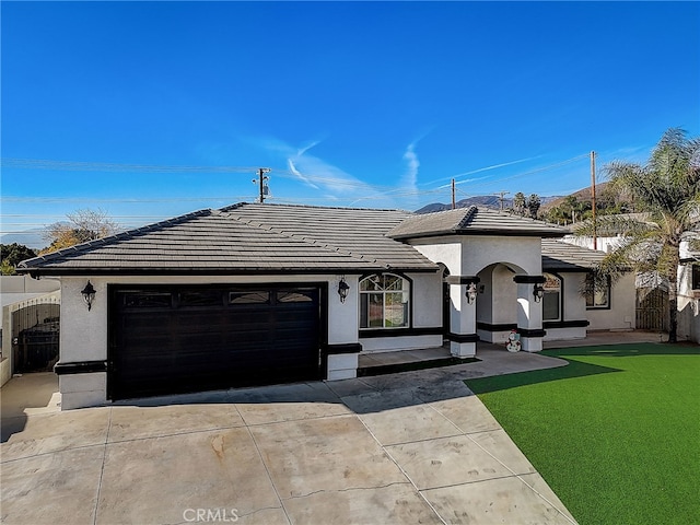 view of front of property featuring stucco siding, concrete driveway, and a tiled roof