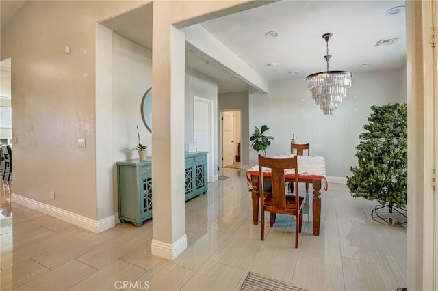 dining space with baseboards, visible vents, and a notable chandelier