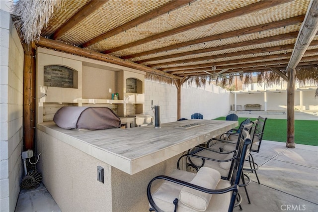 view of patio / terrace featuring fence and outdoor dry bar