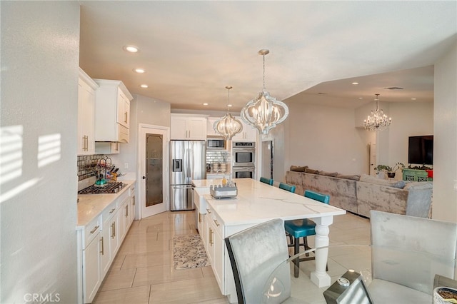 kitchen featuring a large island, stainless steel appliances, recessed lighting, backsplash, and white cabinetry