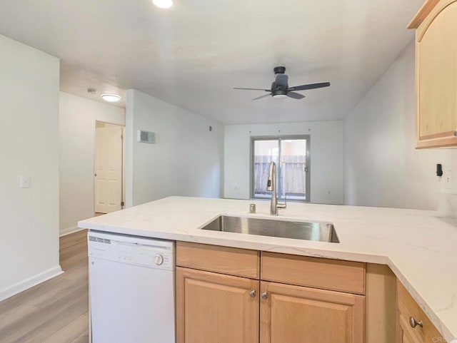 kitchen featuring light brown cabinetry, sink, and white dishwasher