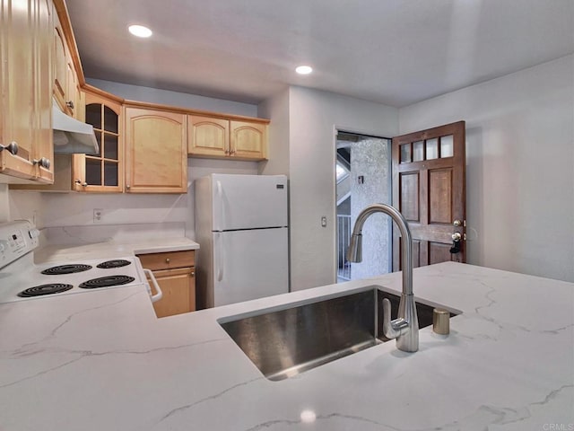 kitchen featuring light brown cabinetry, sink, and white appliances