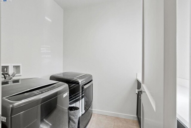 laundry area featuring light tile patterned floors and separate washer and dryer