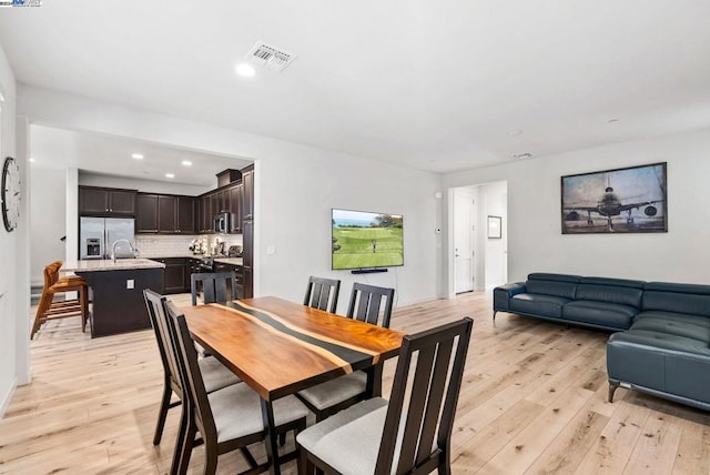 dining area featuring light wood-type flooring and sink