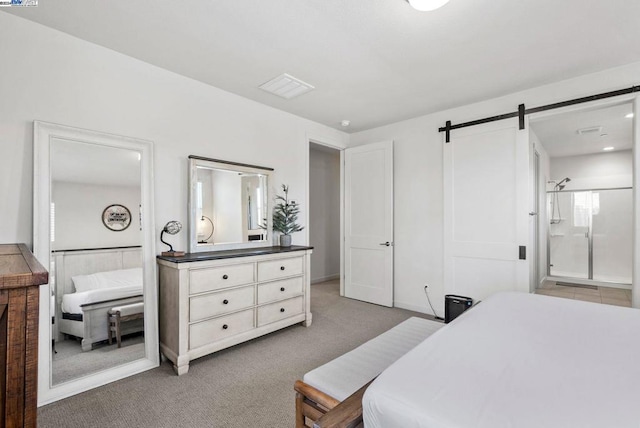 carpeted bedroom featuring a barn door and connected bathroom