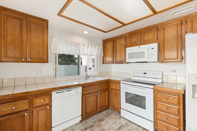 kitchen with sink, tile countertops, and white appliances