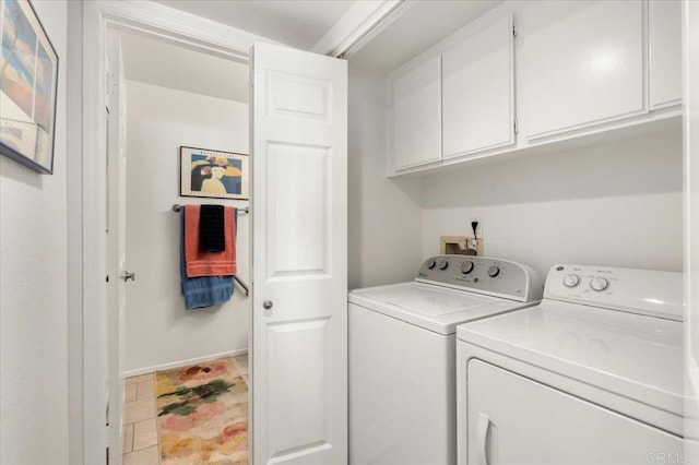 laundry area featuring separate washer and dryer and cabinets