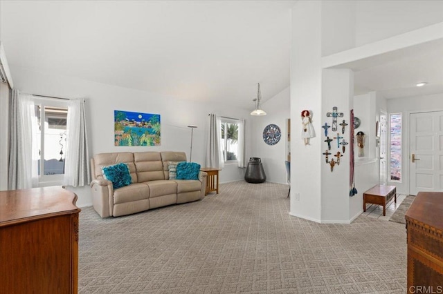 carpeted living room featuring high vaulted ceiling