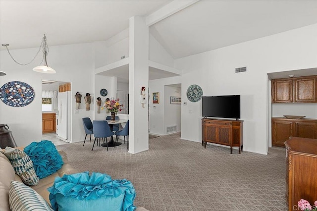 carpeted living room with high vaulted ceiling and beam ceiling