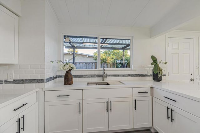 kitchen featuring white cabinetry, sink, wood ceiling, and tasteful backsplash