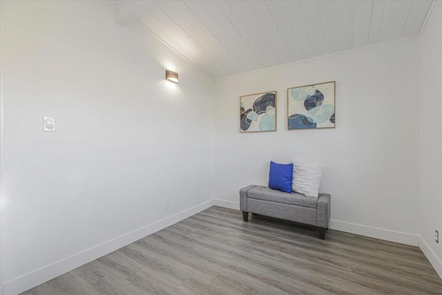 unfurnished room featuring hardwood / wood-style floors, wood ceiling, ornamental molding, and lofted ceiling with beams