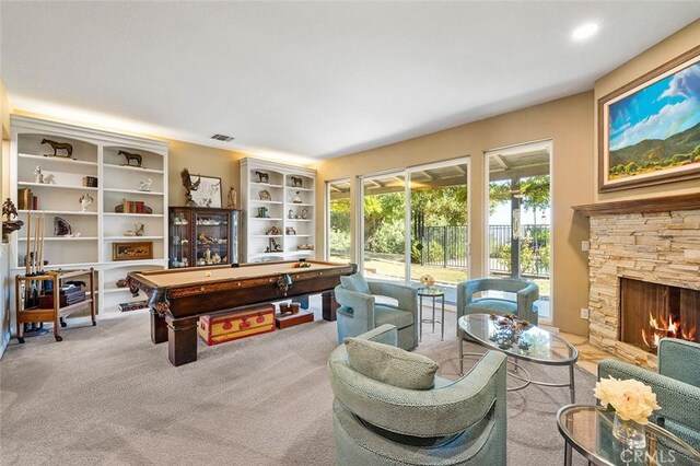 playroom featuring a stone fireplace, light colored carpet, and billiards