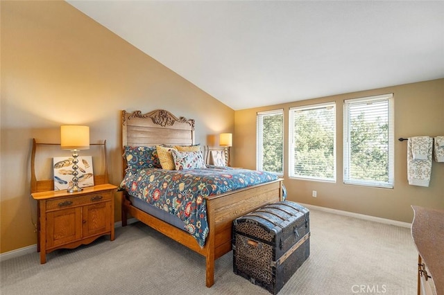 bedroom with light colored carpet, baseboards, and lofted ceiling