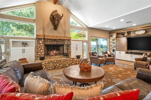 living room with plenty of natural light, a fireplace, and high vaulted ceiling