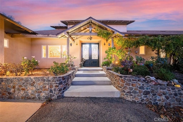 exterior entry at dusk featuring french doors