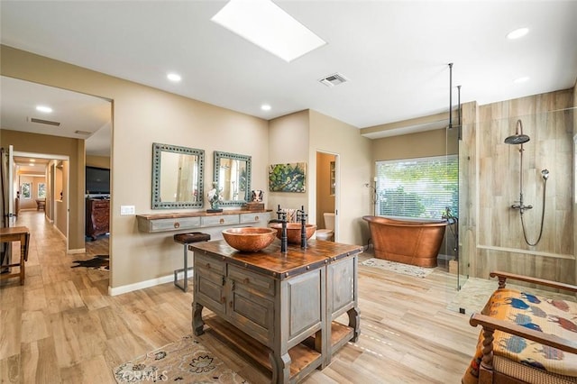 bathroom with vanity, wood-type flooring, independent shower and bath, and a skylight