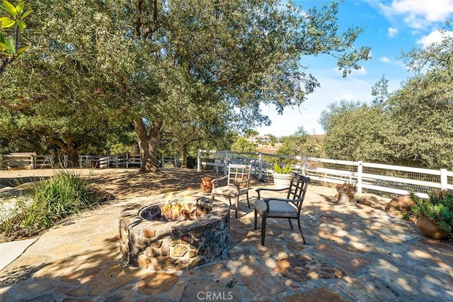 view of patio with an outdoor fire pit and fence