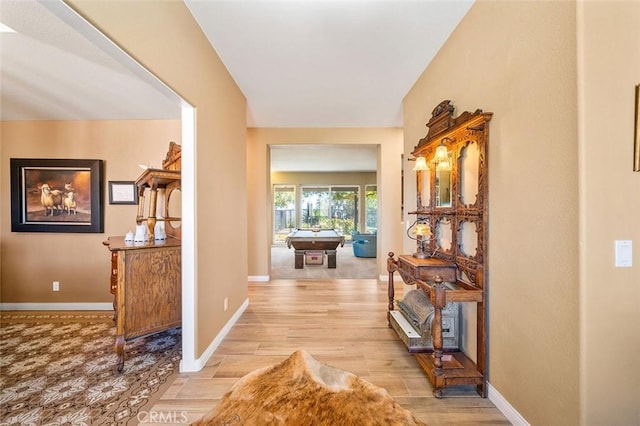 hallway with baseboards and light wood-style floors