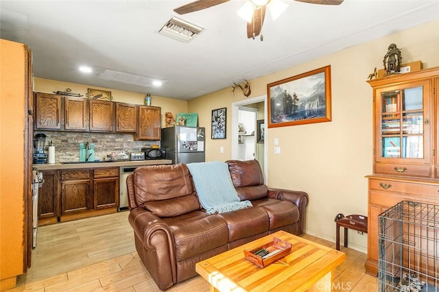 living room featuring light wood finished floors, visible vents, bar area, ceiling fan, and recessed lighting